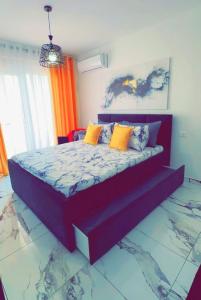a bedroom with a large bed with colorful pillows at Princ Apartment studio in Shëngjin +15 photos