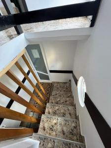 Una escalera en una casa con suelo de mármol y techos de madera en Casa Munții Rodnei, en Borşa