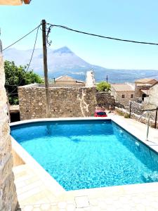 una piscina con vista sulle montagne di Pool House ( Πέτρινο σπίτι με πισίνα ) a Oitylo