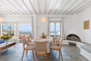 a dining room with a table and chairs and a fireplace at Mykonos Lagom in Mikonos