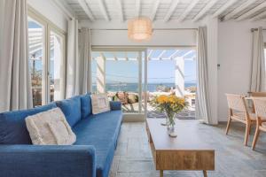 a living room with a blue couch and a table at Mykonos Lagom in Mikonos