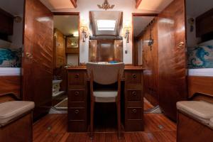 a bathroom with a chair and a vanity and a mirror at Classic Boat Monte-Carlo in Monte Carlo
