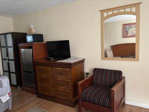 um quarto com uma cadeira, uma secretária e um espelho em Jasmine Garden Inn - Lake City em Lake City