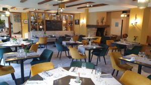 a dining room with tables and chairs in a restaurant at Hotel Le Lion d'Or in Saint-Geniez-dʼOlt