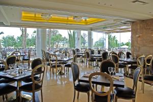 a dining room with tables and chairs and windows at Mediterranean Princess- Adults Only in Paralia Katerinis
