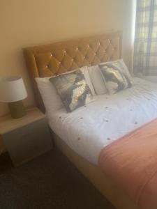 a bedroom with a bed with a headboard and a lamp at Room in Essex in Pitsea