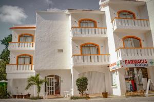 a white building with balconies on the side of it at Hotel Manzana Blanca 5th Avenue in Playa del Carmen