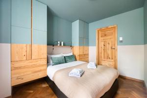 - une chambre avec un grand lit et des serviettes dans l'établissement Praga Strzelecka Cosy Apartment, à Varsovie