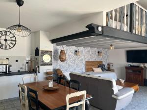 a living room with a bed and a dining room at Appartement mezzanine spacieux in Jaunay-Marigny