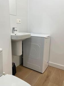 a white bathroom with a sink and a washing machine at Nidito Enamorados in Pamplona