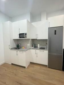 a kitchen with white cabinets and a stainless steel refrigerator at Nidito Enamorados in Pamplona