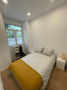 a white bedroom with a bed and a window at Nidito Enamorados in Pamplona