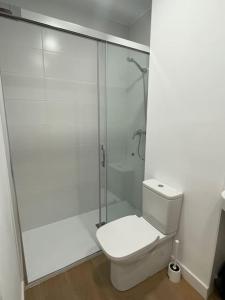 een witte badkamer met een toilet en een douche bij Nidito Enamorados in Pamplona