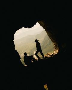twee mensen die in een grot staan bij PUQIO in Yanque