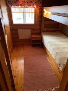 a small room with two bunk beds and a window at Cottages SAA in Punkaharju