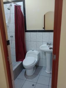 a bathroom with a toilet and a sink at Hostal El Conde in Tacna