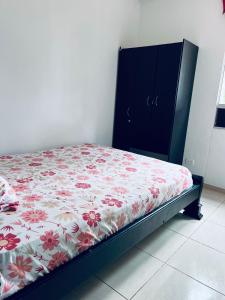 a bedroom with a bed with a floral bedspread and a dresser at ESTANCIA MINIMA 3 NOCHES APARTAMENTO 3 HABITACIONES - 5 PERSONAS no aire acondicionado in Valledupar