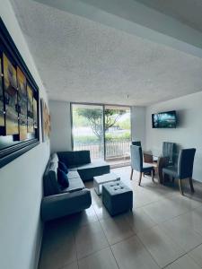 ein Wohnzimmer mit einem Sofa und einem Tisch in der Unterkunft ESTANCIA MINIMA 3 NOCHES APARTAMENTO 3 HABITACIONES - 5 PERSONAS no aire acondicionado in Valledupar
