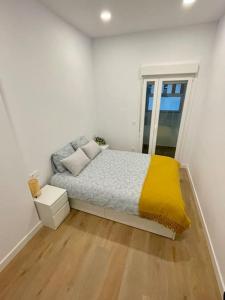 a small bedroom with a bed with a yellow blanket at Nidito Sandua in Pamplona