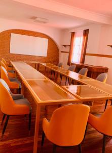 een conferentieruimte met houten tafels en stoelen bij Hotel Les Cygnes in Antananarivo