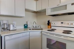 a white kitchen with a stove and a sink at 0204 Seaside Sanctuary by Atlantic Towers in Carolina Beach