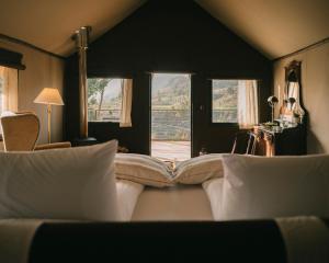 a bedroom with a bed with pillows and a window at PUQIO by Andean in Yanque