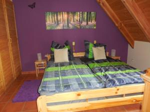 ein Schlafzimmer mit einem Holzbett mit einer lila Wand in der Unterkunft Ferienwohnung Kribitz Hodenhagen in Hodenhagen