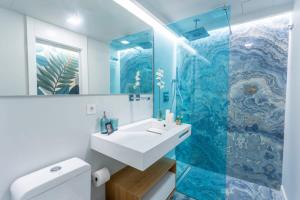y baño con lavabo y ducha acristalada. en Eleven Boutique Apartments, en Las Palmas de Gran Canaria