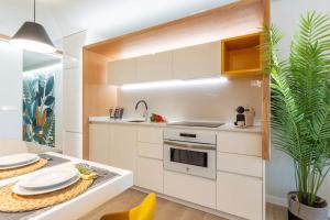 una cocina con armarios blancos, una mesa y una planta en Eleven Boutique Apartments, en Las Palmas de Gran Canaria