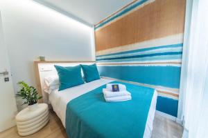 1 dormitorio con 1 cama con sábanas azules y toallas en Eleven Boutique Apartments, en Las Palmas de Gran Canaria
