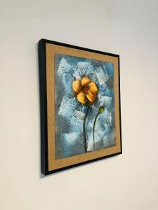 a picture of a yellow flower on a wall at Apartamento amueblado in La Romana