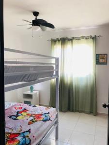 een slaapkamer met een stapelbed en een plafondventilator bij Apartamento amueblado in La Romana