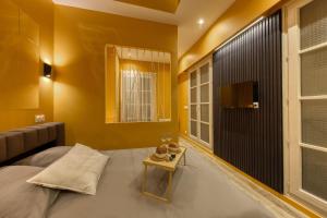 a bedroom with yellow walls and a bed with a table at Deluxe SPA suite caramel sweetness in Melun +8 photos