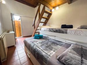 1 dormitorio con 2 camas y escalera en Apt Finestra Sul Castello, Vista Lago Wi-Fi Gratis, en Bracciano