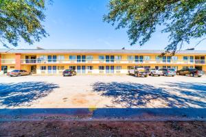 un gran edificio con coches estacionados frente a él en Castle Inn & Suites By OYO Chickasha, en Chickasha