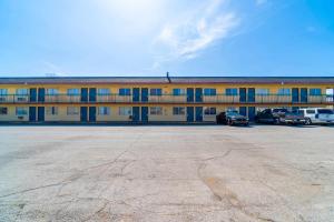 un gran edificio con coches estacionados en un estacionamiento en Castle Inn & Suites By OYO Chickasha, en Chickasha