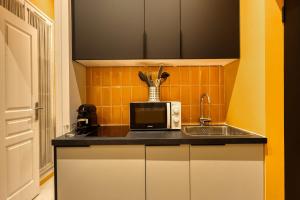 a kitchen with a sink and a microwave at Deluxe SPA suite caramel sweetness in Melun