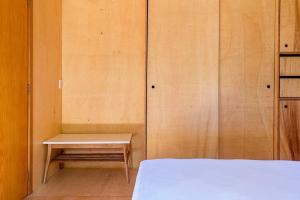 Zimmer mit einem Bett und einer Bank in der Unterkunft Casa de Piedra - Pousada NaCarapina in São Francisco de Paula