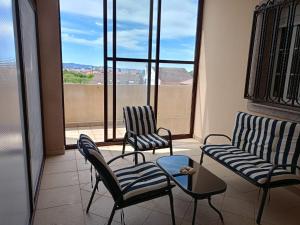 2 chaises et une table devant une fenêtre dans l'établissement Apartamento Teresa, à Cambados