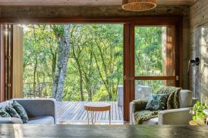 ein Wohnzimmer mit einer großen Glasschiebetür in der Unterkunft Casa de Piedra - Pousada NaCarapina in São Francisco de Paula + 32 Fotos