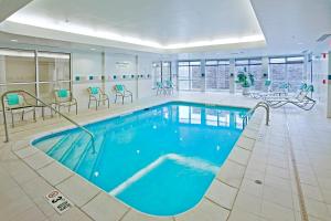 a pool in a hotel with blue water in a room at Courtyard Des Moines Ankeny in Ankeny