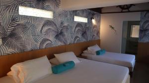 1 dormitorio con 2 camas y un mural en la pared en Hotel Rosario de Mar by Tequendama, en Isla Grande