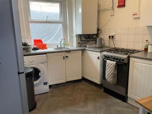 a kitchen with a stove and a washing machine at RAHAL HACKNEY in London