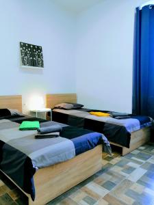a room with three beds with blue curtains at Pula Center Colosseum Apartments in Pula