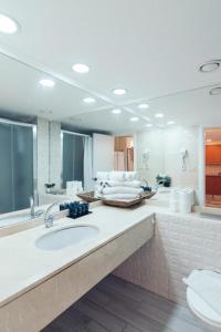 La salle de bains est pourvue d'un lavabo et d'un grand miroir. dans l'établissement beutifull apartments by the sea, à Haïfa