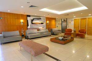 a lobby with couches and chairs and a tv at Hotel Premium Campinas in Campinas