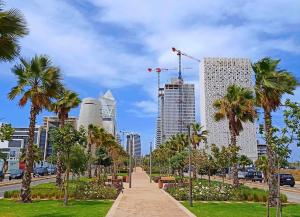 a walkway in a park with palm trees and buildings at Tour 33 : Appartement chic en plein cœur de Casa in Casablanca