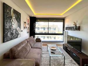 a living room with a couch and a table at Tour 33 : Appartement chic en plein cœur de Casa in Casablanca