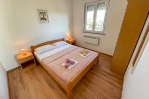 sypialnia z łóżkiem z dwoma ręcznikami w obiekcie Apartment BOSS w Novalji
