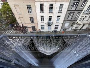 een glazen raam met uitzicht op een gebouw bij Cozy South-Up and Ground in Brussel